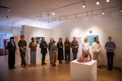 a row of students standing in art gallery