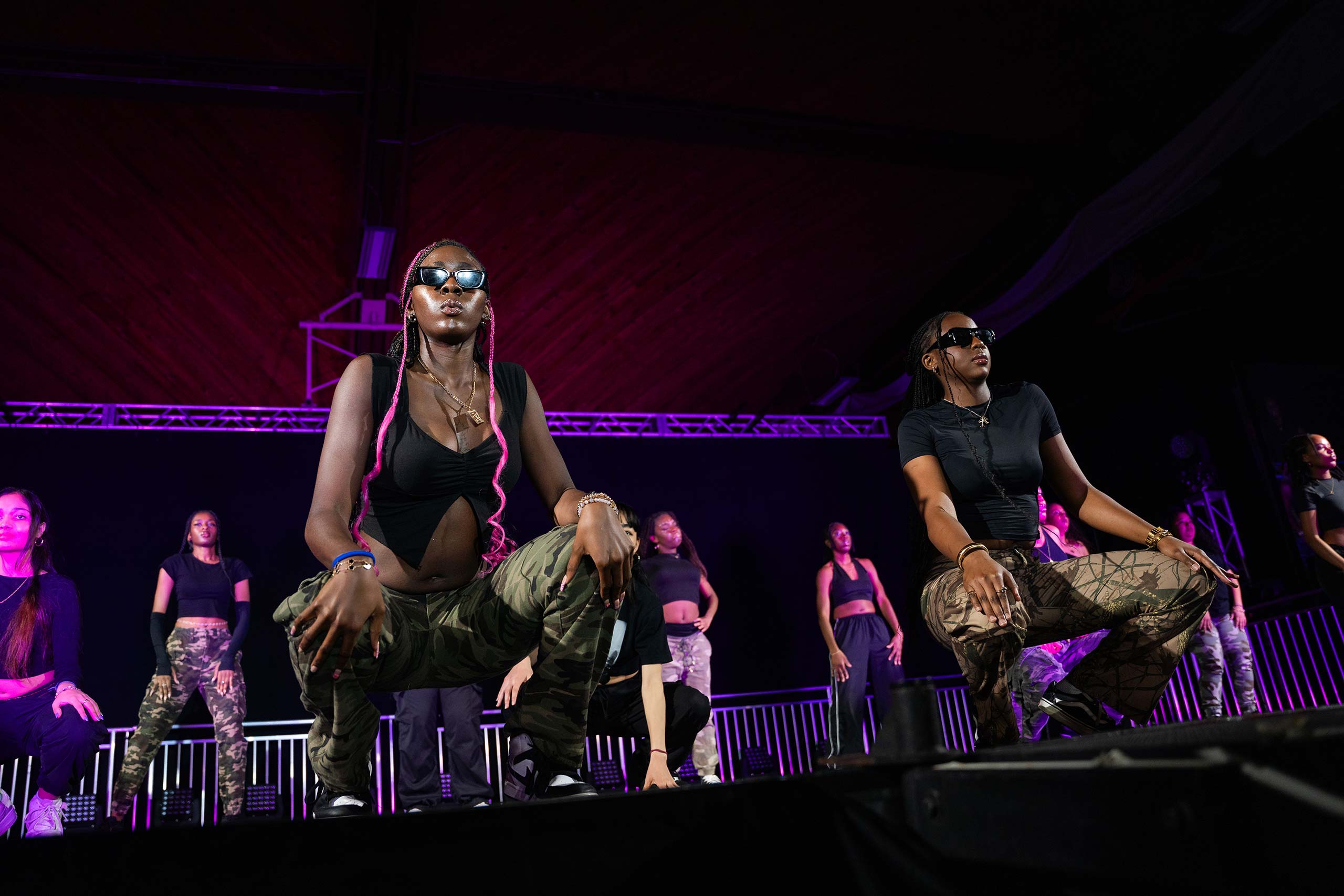 Students squat  during a dance performance at the 2024 Gala event