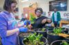 professor and students with potted plants