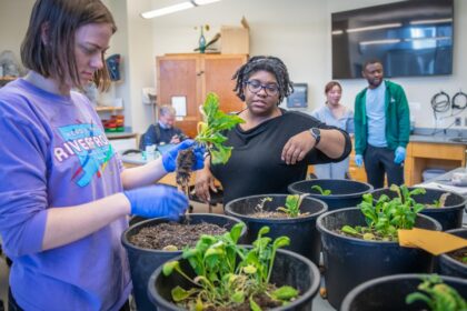 professor and students with potted plants