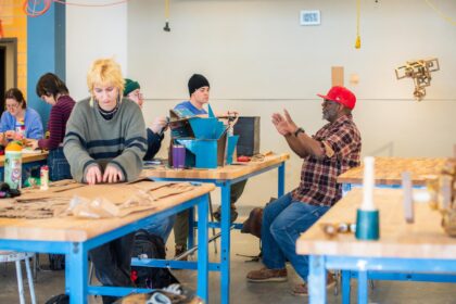 professor and students gathered at work tables