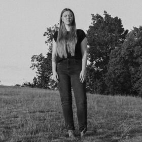 woman stands in field