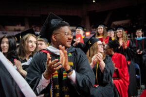 students clapping at commencement