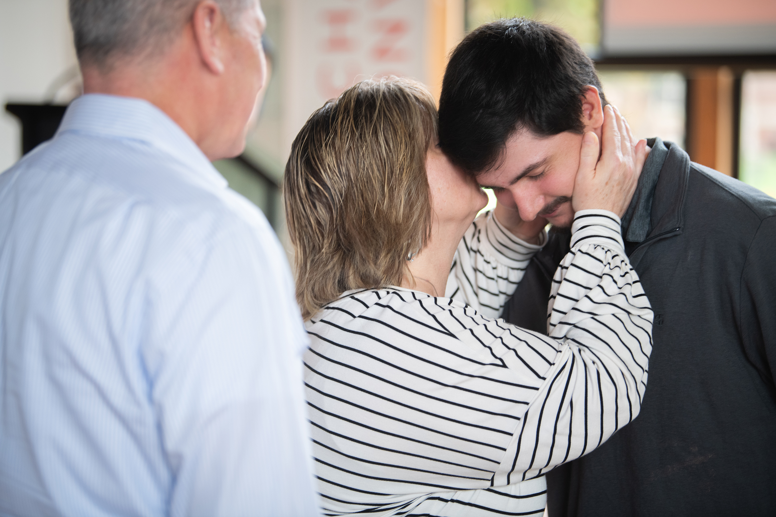 Student receives first-gen pin from his parents at ceremony