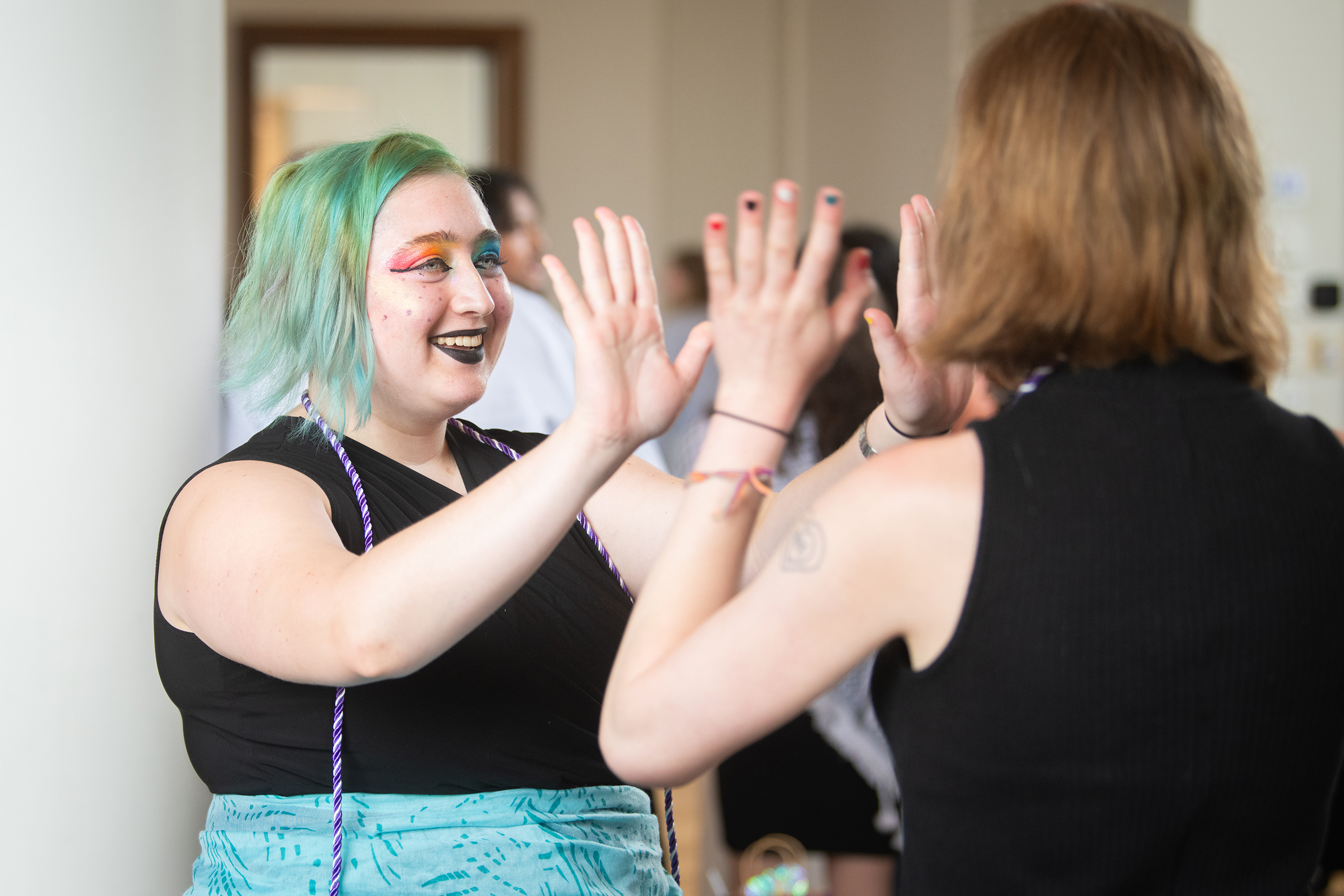 Students high-five at Lavender Graduation