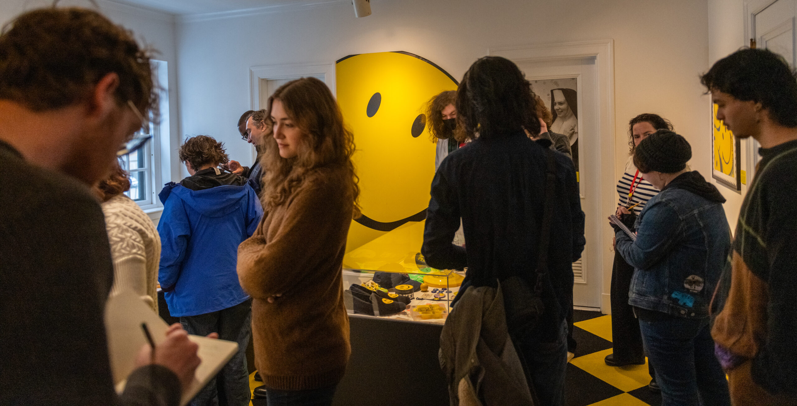 students in museum with smiley face art