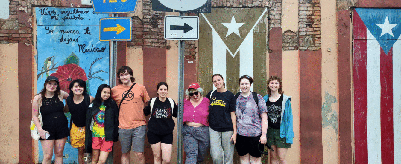 Group of Clark students posing in front of mural on wall in Puerto Rico