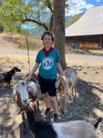 student standing with goats