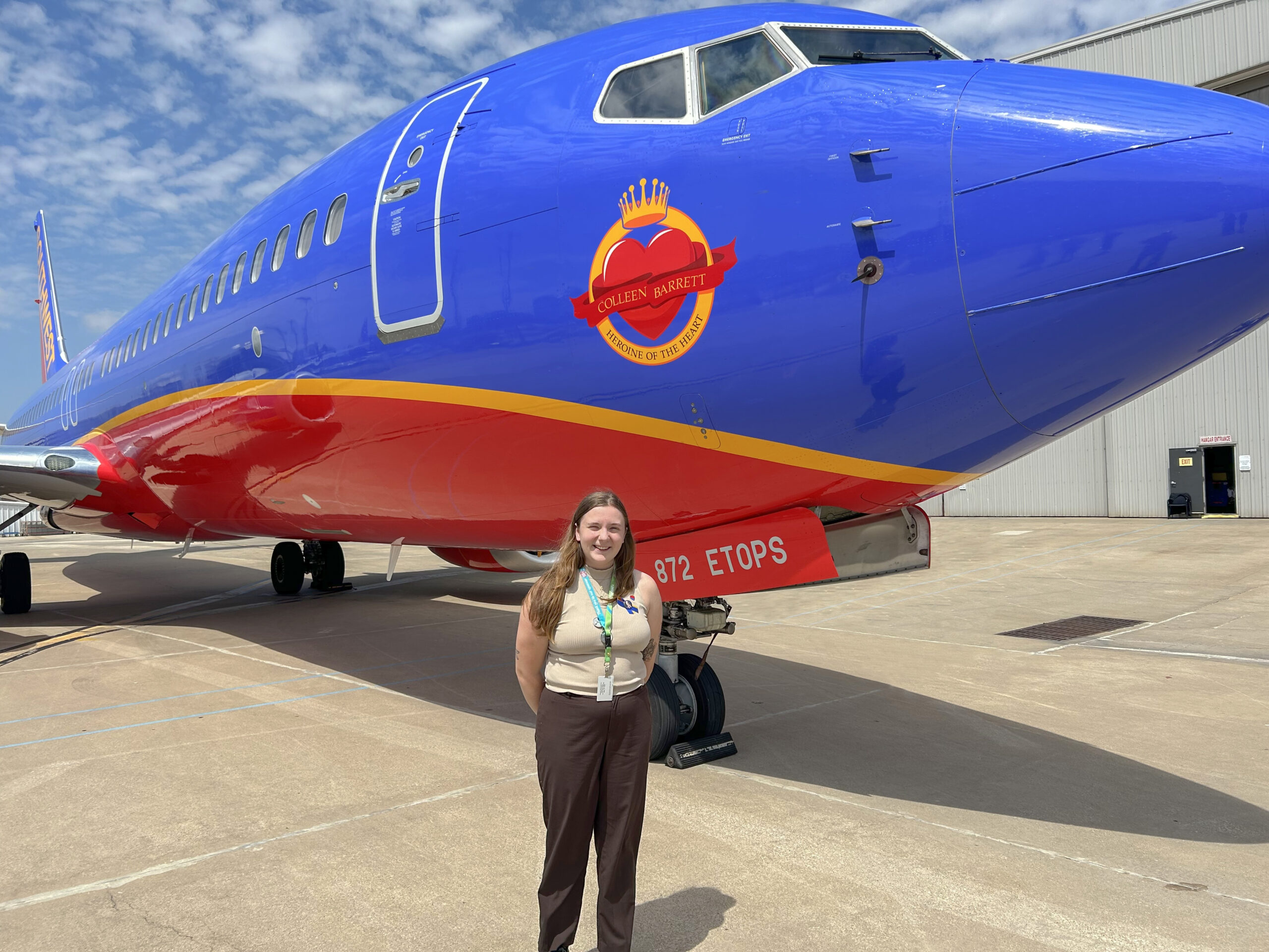 woman standing in front of blue airplane