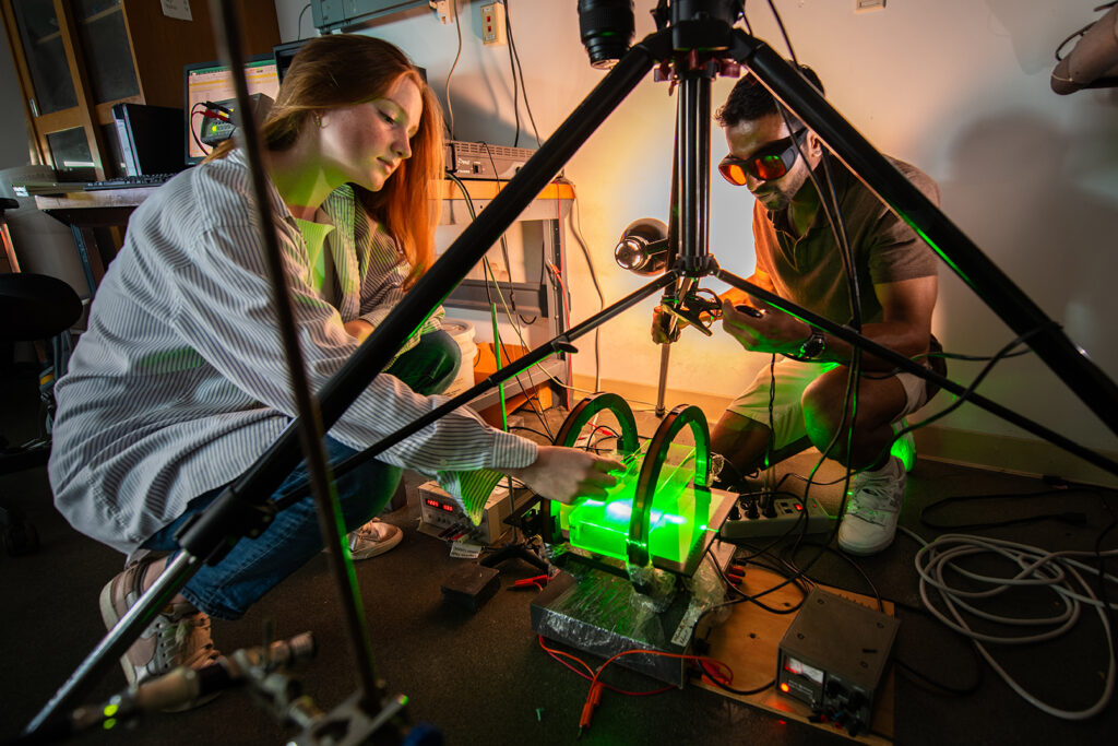 Lily Carey ’25 and Balaram Desai ’24 work with the Hemholtz coil, used for experiments with magneto-elastic worms.