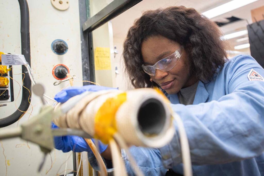 A student working with mechanical equipment in a lab, Clark University.