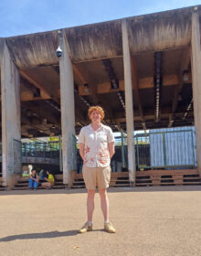 student in front of building