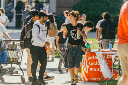 students walk on campus during club fair