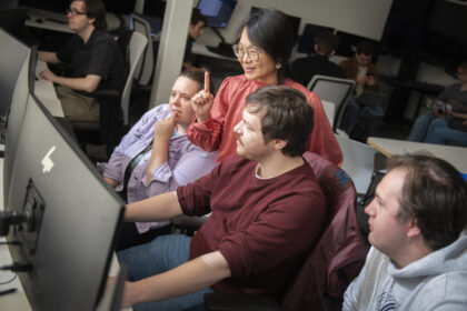 professor works with students at computers