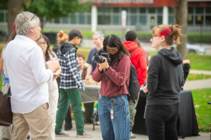 student holds camera to record interview