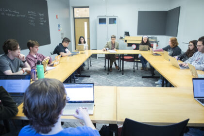 students sit around square table