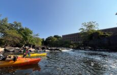 kayakers in water near old mill