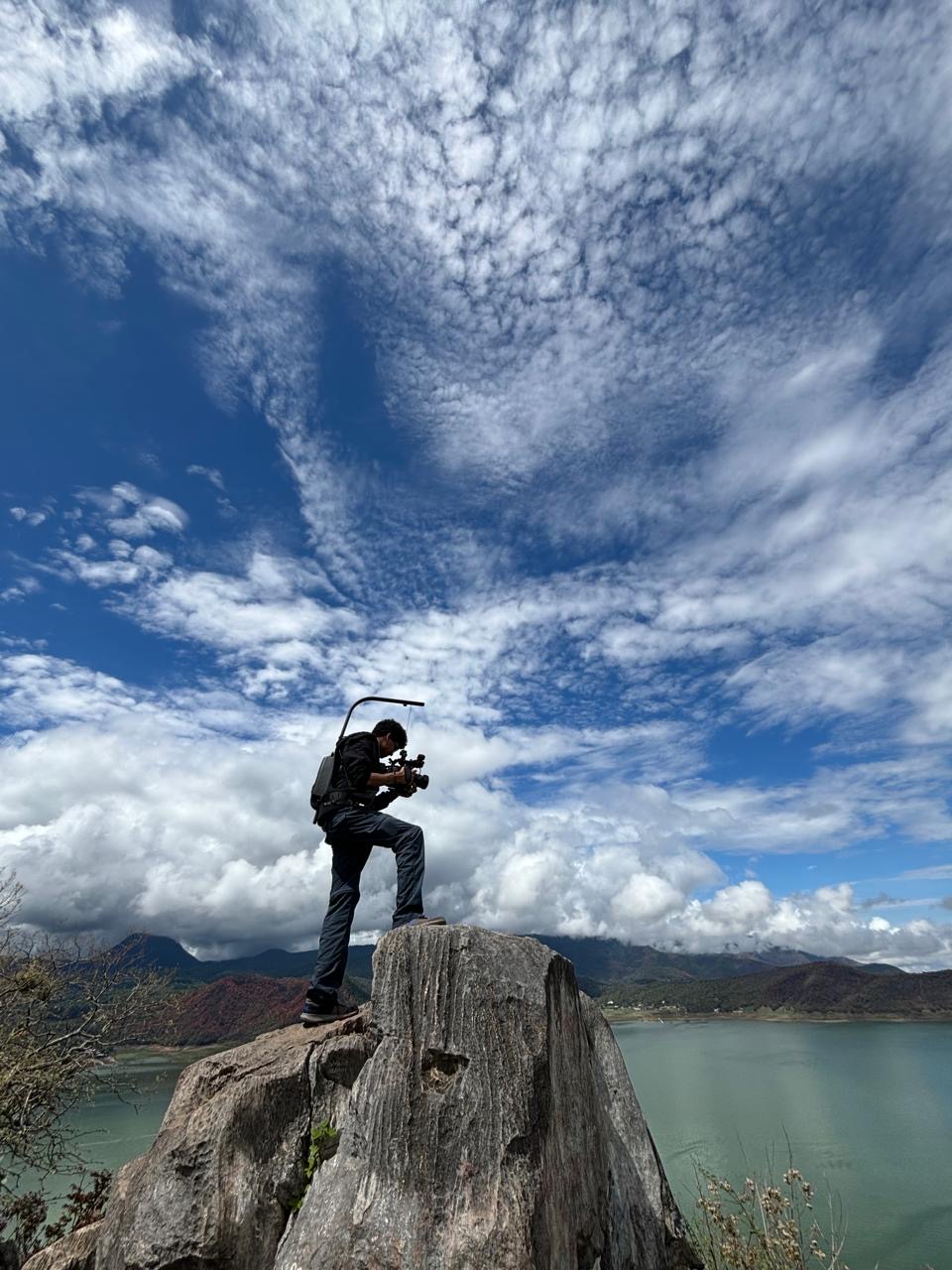 student filming on rock