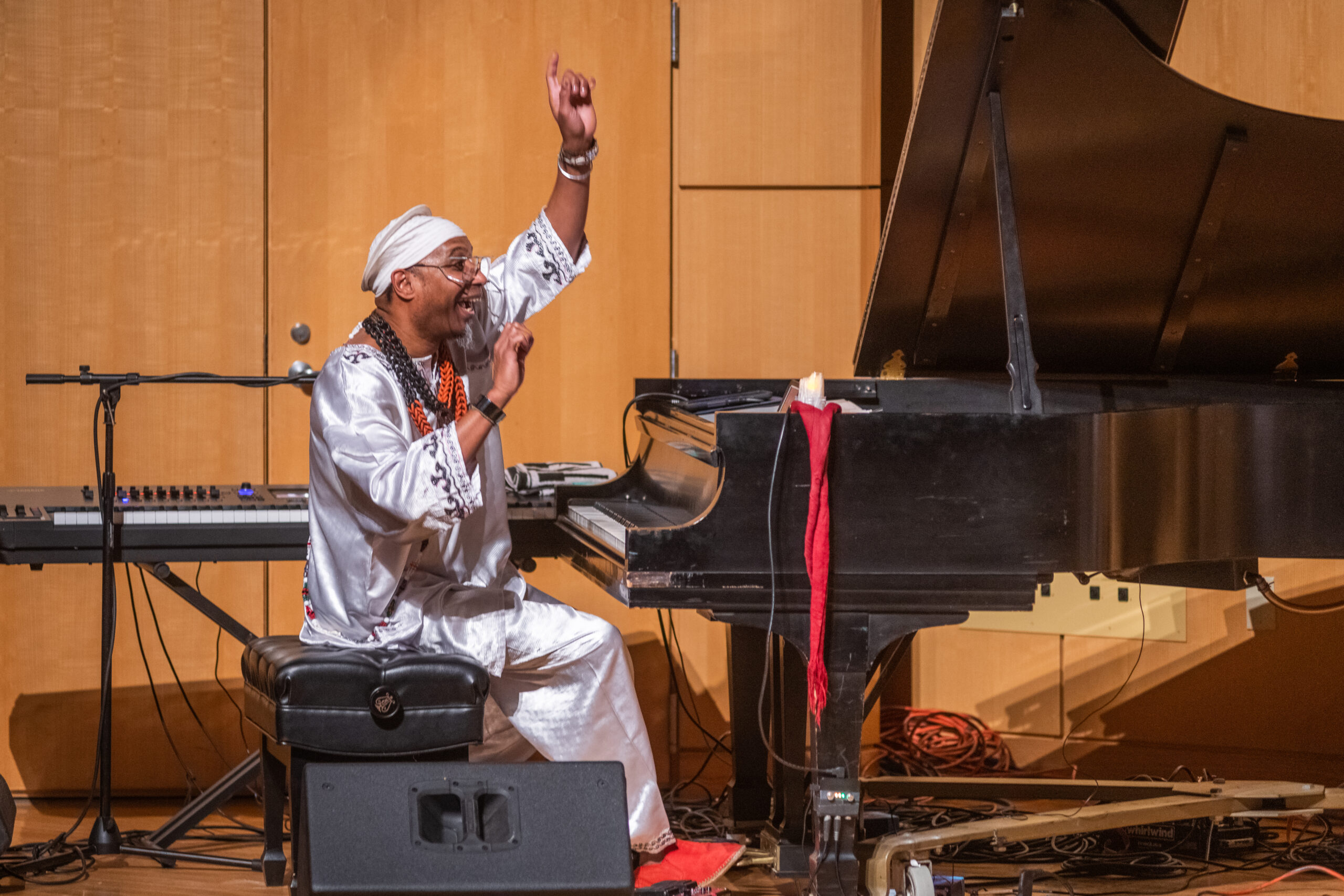 man in white clothes playing grand piano