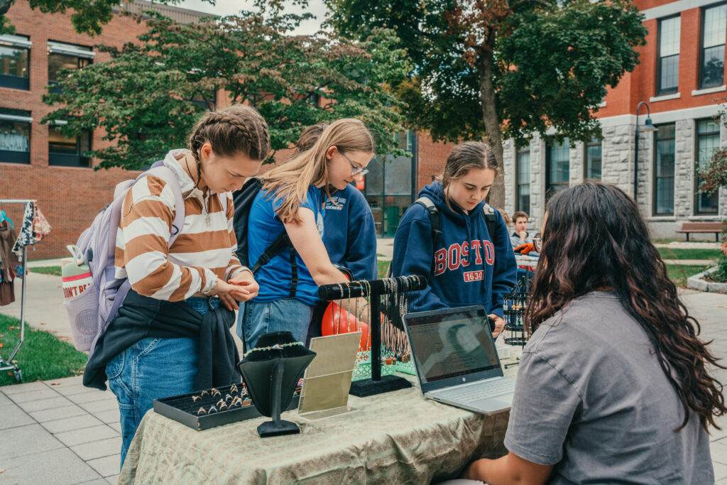 students browse jewelry at outdoor market