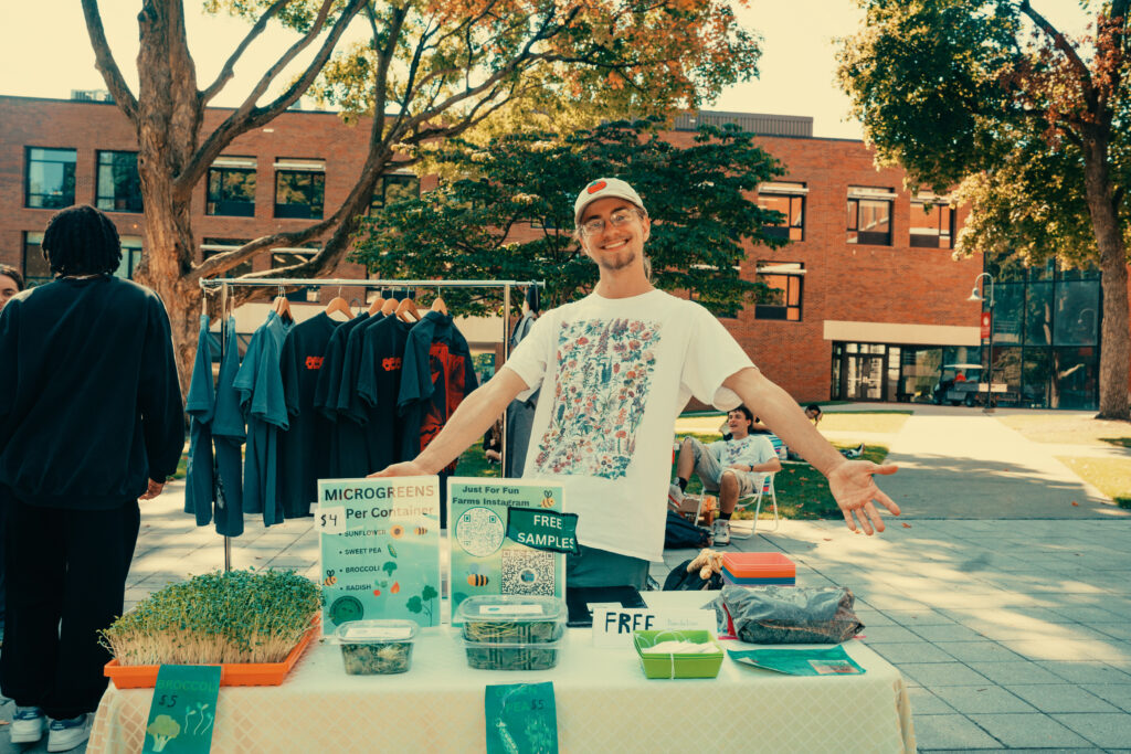 student poses with microgreens on table