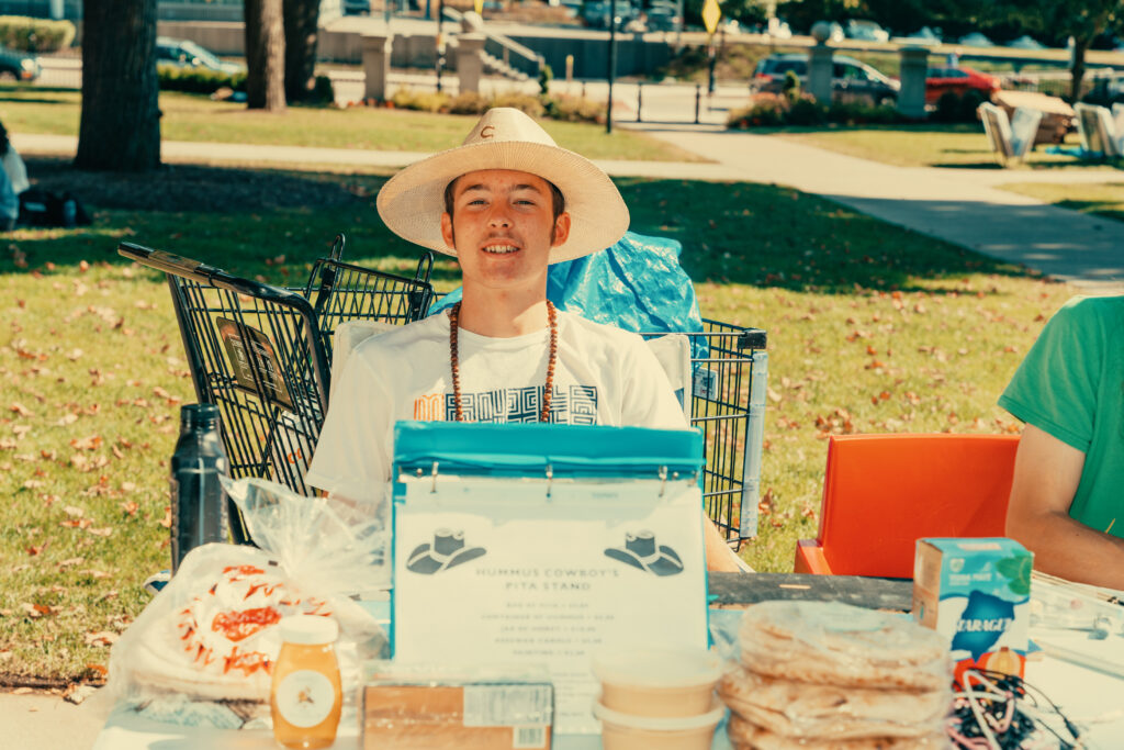 student poses for photo at outdoor market