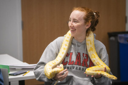 student holds yellow snake