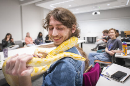 student holds yellow snake