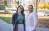 two students pose for photo on campus green