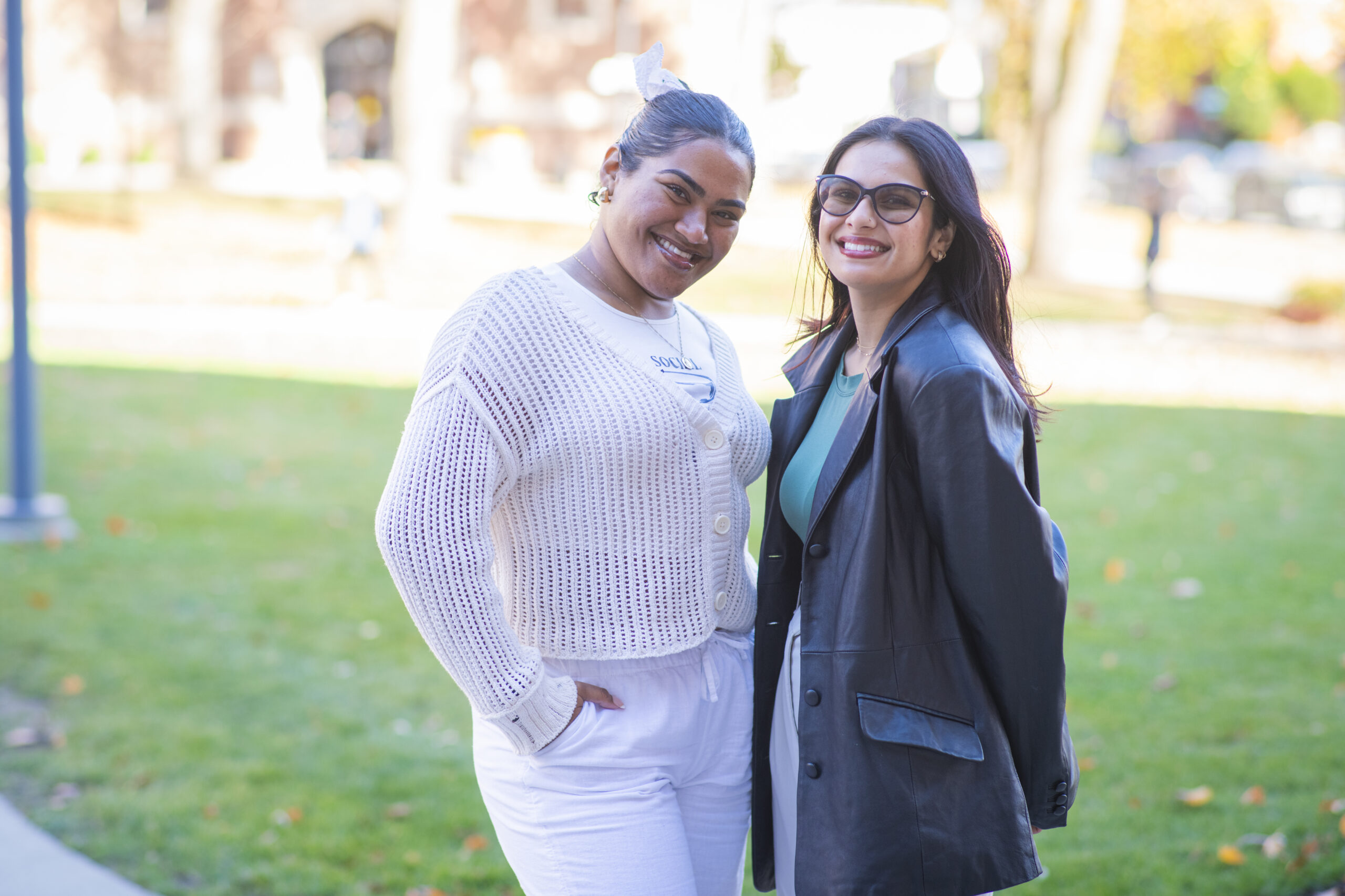 two students pose for photo on campus green