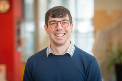 headshot of man in blue sweater