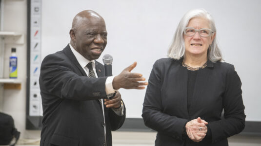 man with microphone stands next to woman