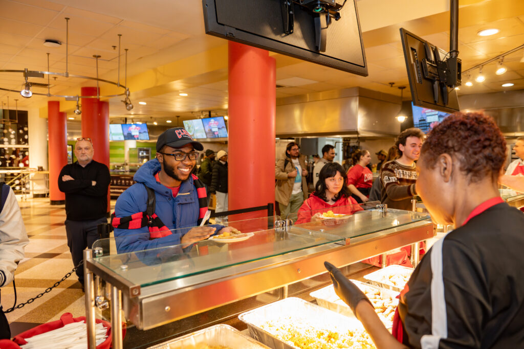 faculty serve students in the dining hall during late-night breakfast