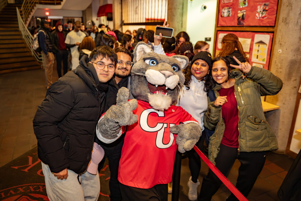 faculty serve students in the dining hall during late-night breakfast