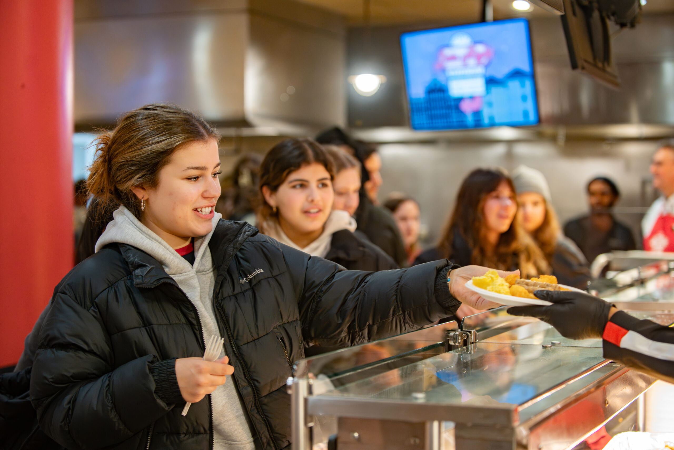 faculty serve students in the dining hall during late-night breakfast