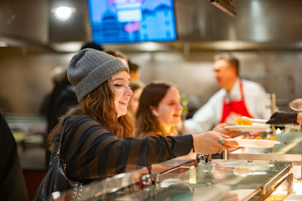 faculty serve students in the dining hall during late-night breakfast