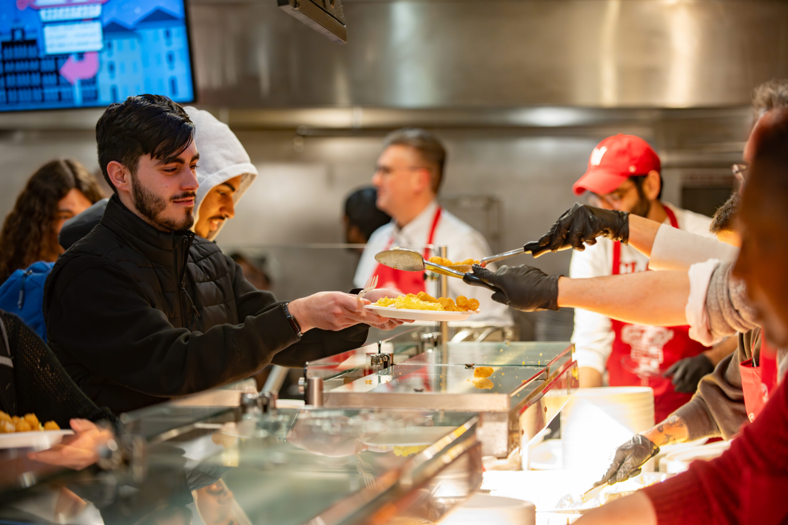 faculty serve students in the dining hall during late-night breakfast