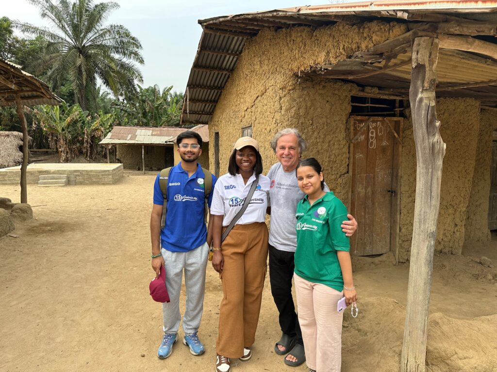 four people pose for photo outside