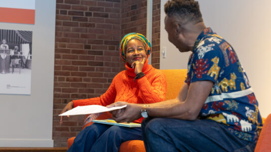 author and professor sitting in chairs talking