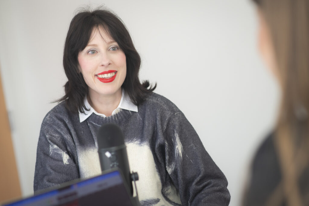 woman speaks into podcast microphone